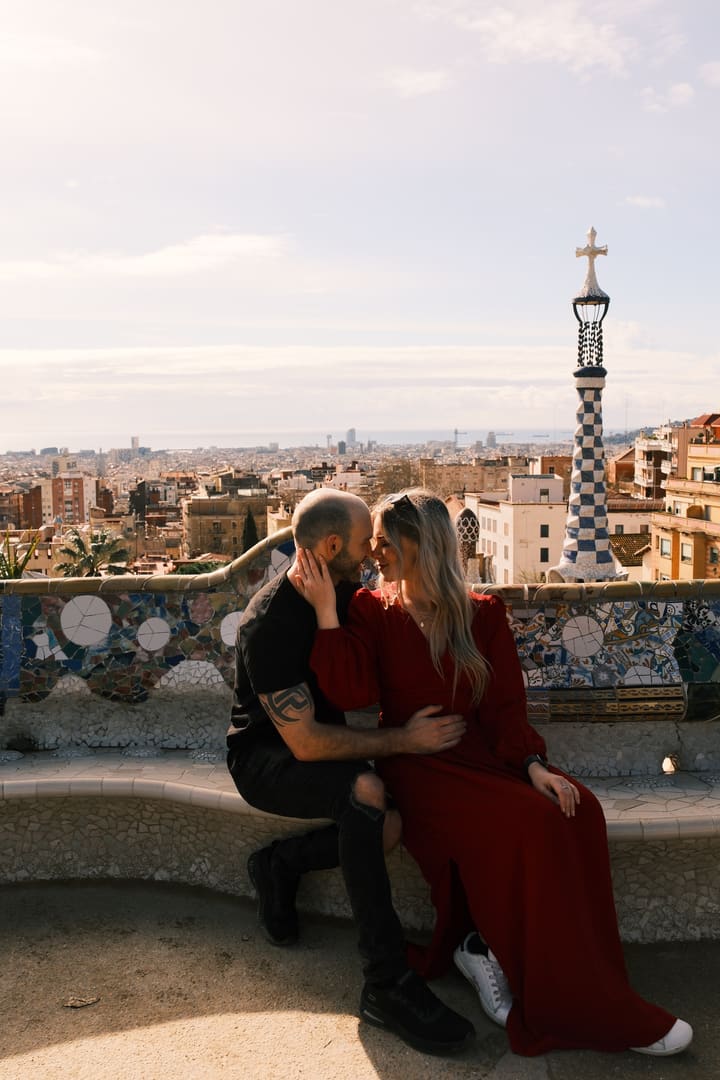 Polibek na mozaikové lavici parku Güell nad střechami Barcelony